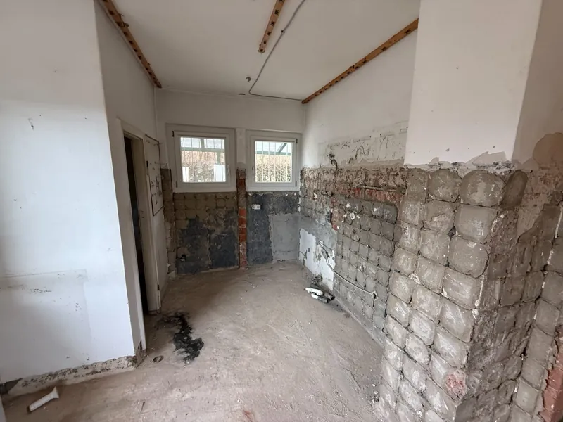 Zurückgebaute Küche mit freigelegtem Fliesenkleber an der Wand